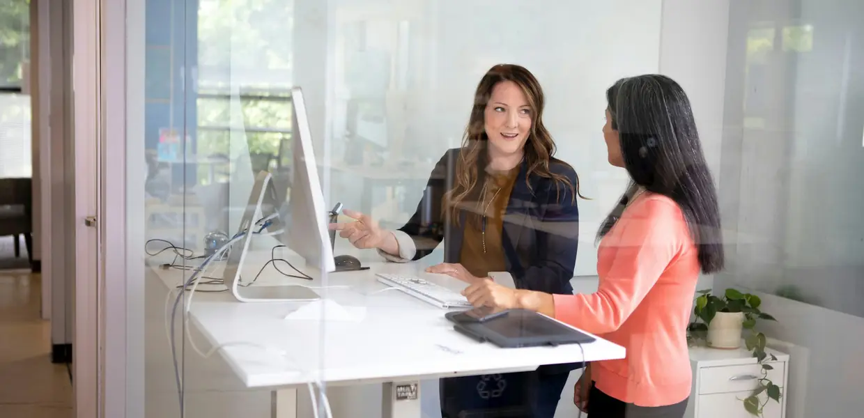 Two colleagues planning at a standing desk