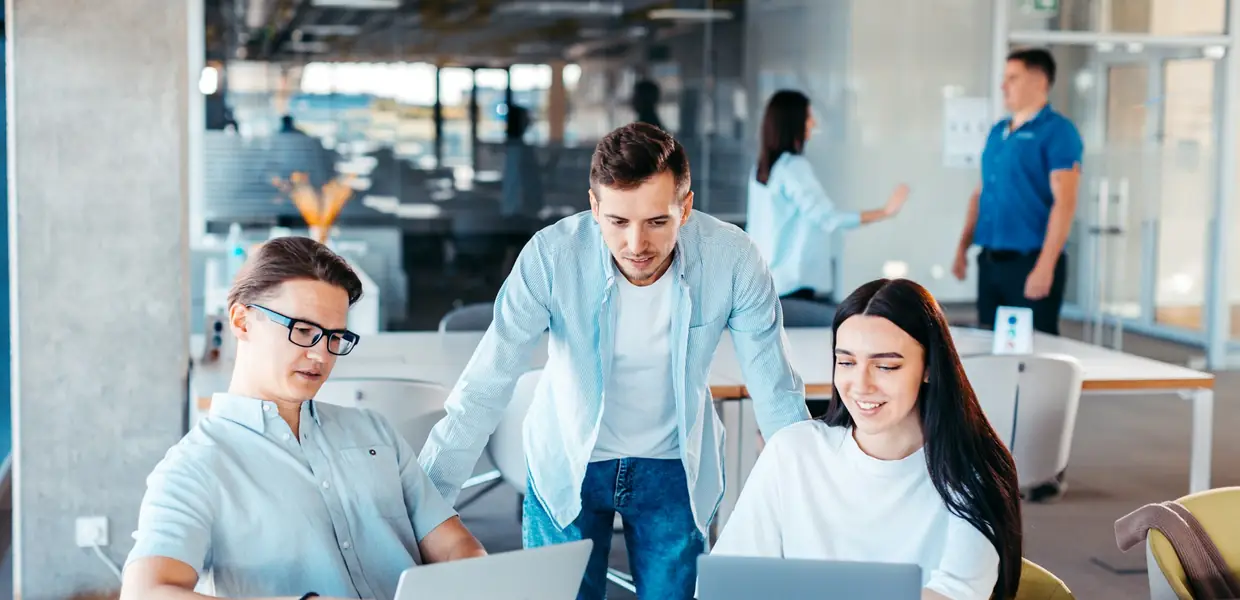 A consulting team working together on laptops